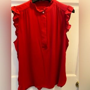 Red sleeveless collared blouse.